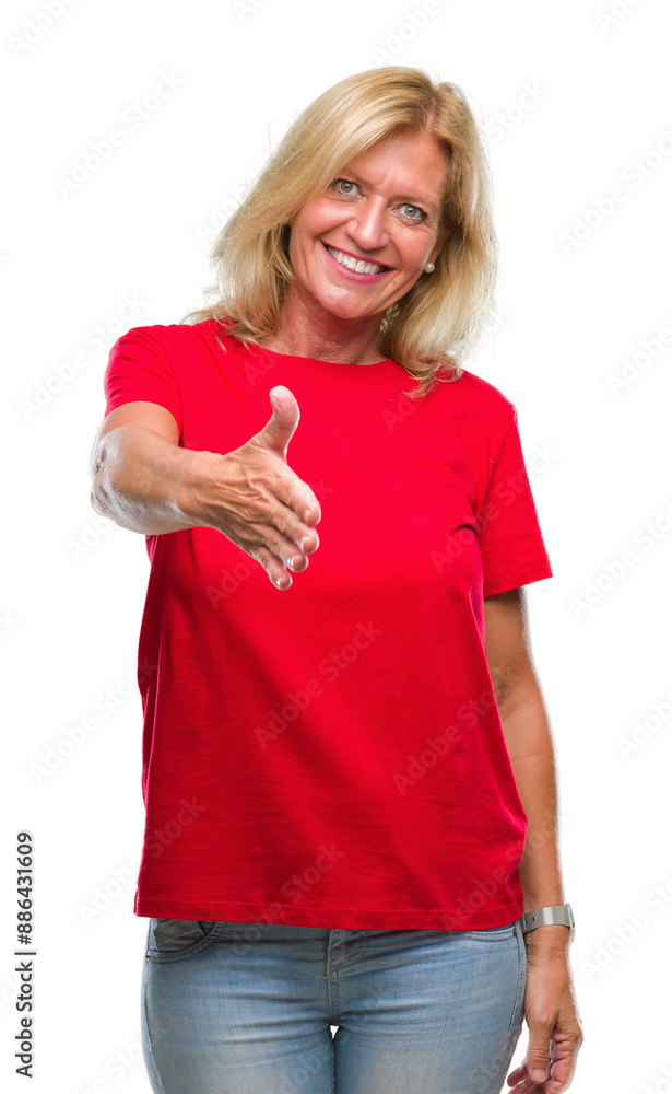Middle age blonde woman over isolated background smiling friendly offering handshake as greeting and welcoming. Successful business. Middle age blonde woman over isolated background smiling friendly offering handshake as greeting and welcoming. Successful business.