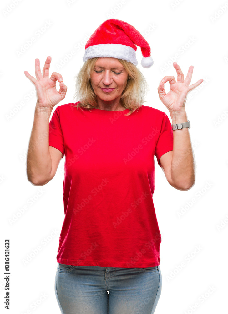 Middle age blonde woman wearing christmas hat over isolated background relax and smiling with eyes closed doing meditation gesture with fingers. Yoga concept. Middle age blonde woman wearing christmas hat over isolated background relax and smiling with eyes closed doing meditation gesture with fingers. Yoga concept.