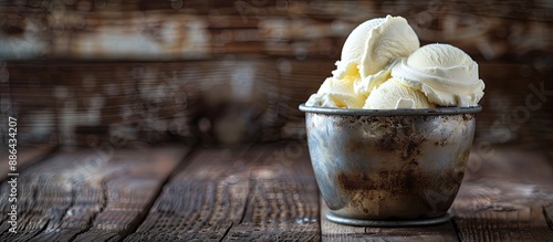 Ice cream in a homemade aesthetic nestled in a frosty metal container set against a rich dark wood backdrop providing ample copy space image