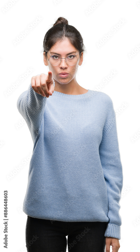 Young beautiful hispanic woman wearing a bun pointing with finger to the camera and to you, hand sign, positive and confident gesture from the front Young beautiful hispanic woman wearing a bun pointing with finger to the camera and to you, hand sign, positive and confident gesture from the front