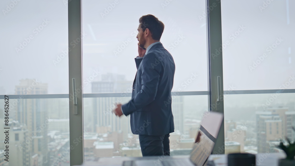Businessman talking phone call negotiations standing at office panoramic window Businessman talking phone call negotiations standing at office panoramic window
