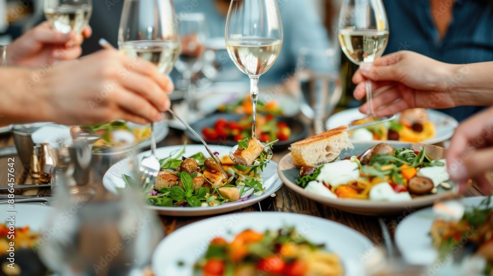 A group of friends dining together enjoys a gourmet meal complete with glasses of white wine, celebrating friendship and good food in a warm and inviting setting. A group of friends dining together enjoys a gourmet meal complete with glasses of white wine, celebrating friendship and good food in a warm and inviting setting.