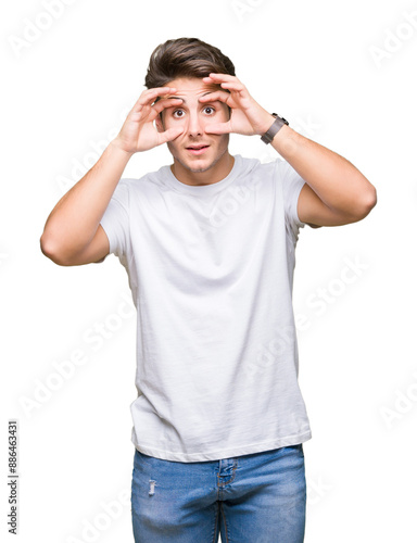 Young handsome man wearing white t-shirt over isolated background Trying to open eyes with fingers, sleepy and tired for morning fatigue