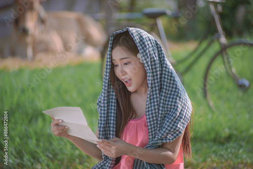 Asian beautiful rural women smiles happily when she receives a letter from her lover who is a soldier for national defense on the border. photo