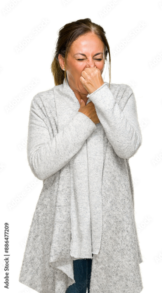 Beautiful middle age adult woman wearing winter sweater over isolated background smelling something stinky and disgusting, intolerable smell, holding breath with fingers on nose. Bad smells concept. Beautiful middle age adult woman wearing winter sweater over isolated background smelling something stinky and disgusting, intolerable smell, holding breath with fingers on nose. Bad smells concept.