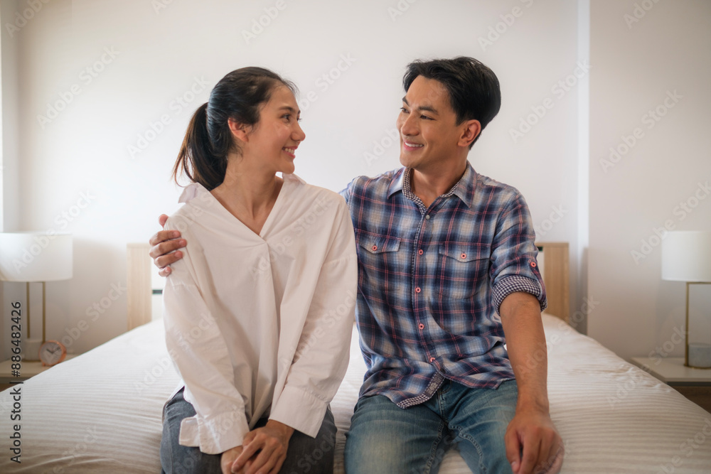 Happy married couple sitting in bedroom with comfortable mattress on moving day. Family New Home, Moving in, relocation. Happy married couple sitting in bedroom with comfortable mattress on moving day. Family New Home, Moving in, relocation.