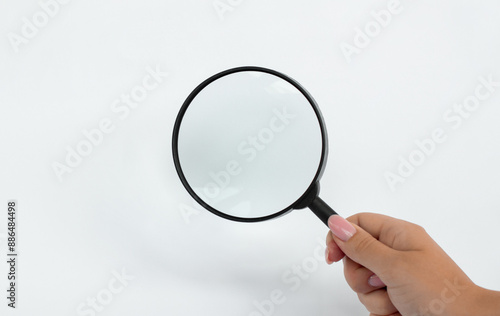 Hand holding Magnifying Glass isolated on white background