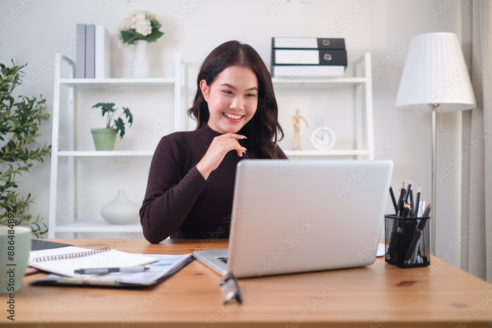 Charming young woman working with laptop while sitting at comfortable workplace. Charming young woman working with laptop while sitting at comfortable workplace.