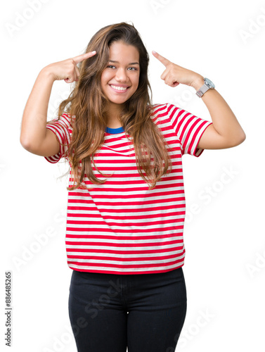 Young beautiful brunette woman wearing stripes t-shirt over isolated background Smiling pointing to head with both hands finger, great idea or thought, good memory