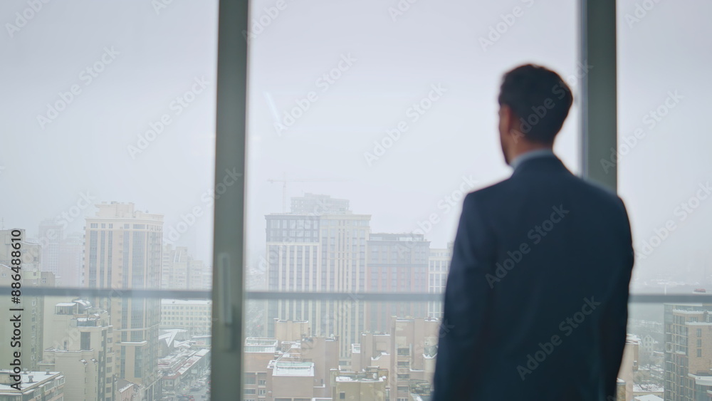 Thoughtful boss resting office contemplating gloomy city back view. Man thinking Thoughtful boss resting office contemplating gloomy city back view. Man thinking
