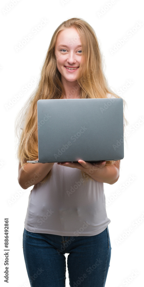 Naklejka premium Blonde teenager woman using computer laptop with a happy face standing and smiling with a confident smile showing teeth