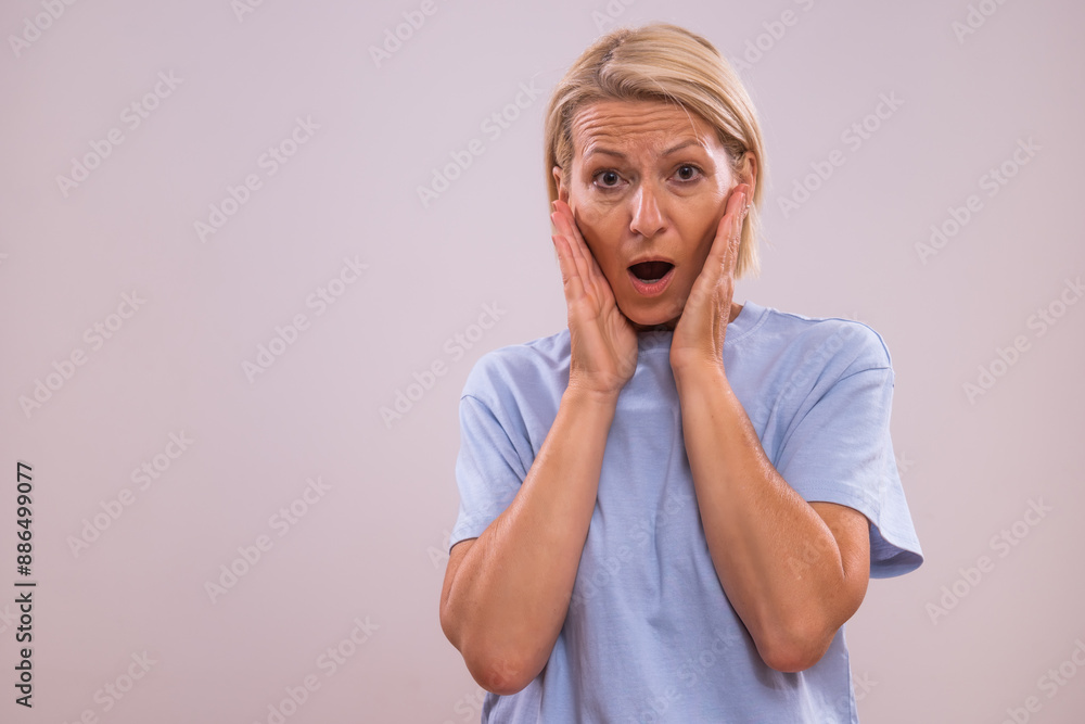 Portrait of shocked mature woman looking on the gray background. Portrait of shocked mature woman looking on the gray background.