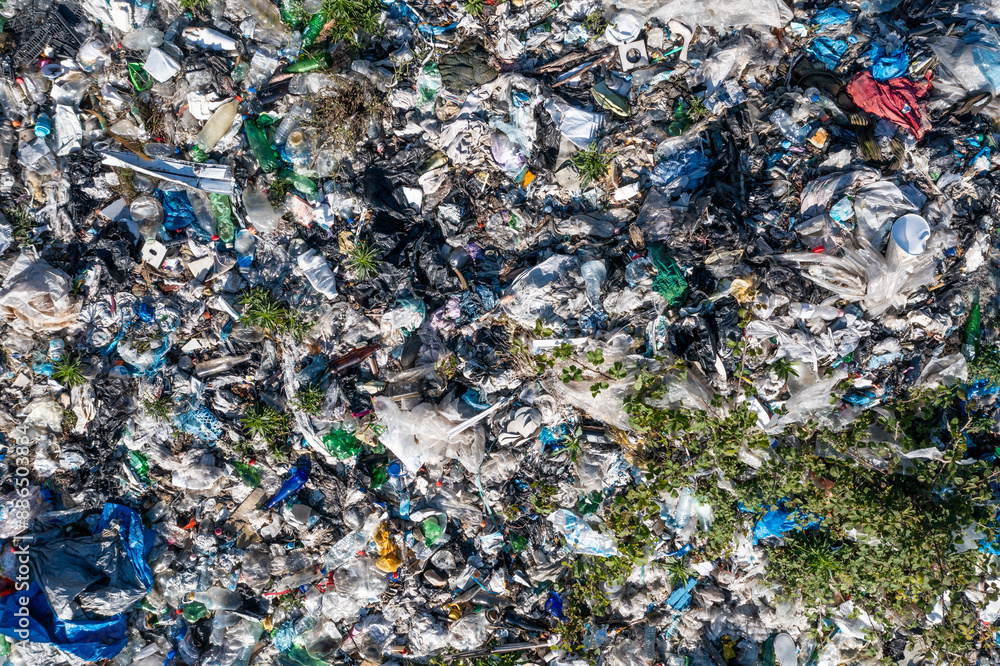Aerial top view of large urban landfill filled with various types of waste and scattered greenery, environmental pollution. Aerial top view of large urban landfill filled with various types of waste and scattered greenery, environmental pollution.