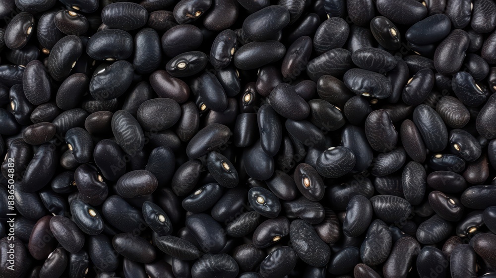 Black beans scattering, each bean highlighting its dark, glossy texture and robust flavor Black beans scattering, each bean highlighting its dark, glossy texture and robust flavor