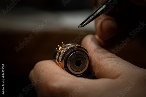 Jeweler puts diamond to golden wedding luxury ring.