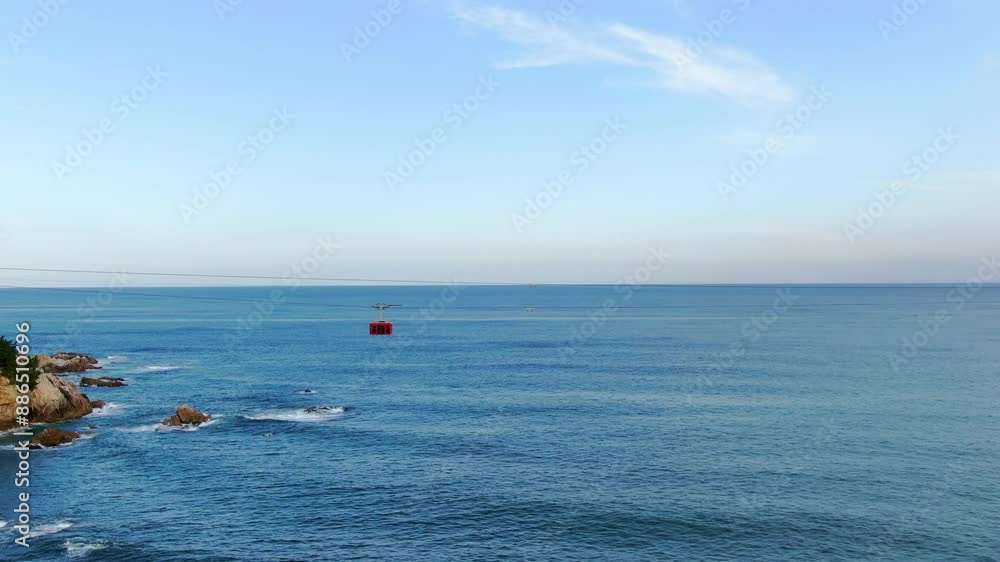 A beautiful view of the beach in Gangwon-do, Korea, a 4k high definition shot of the emerald blue sea with a drone from the sky, and a cable car passing over the sea_1 A beautiful view of the beach in Gangwon-do, Korea, a 4k high definition shot of the emerald blue sea with a drone from the sky, and a cable car passing over the sea_1