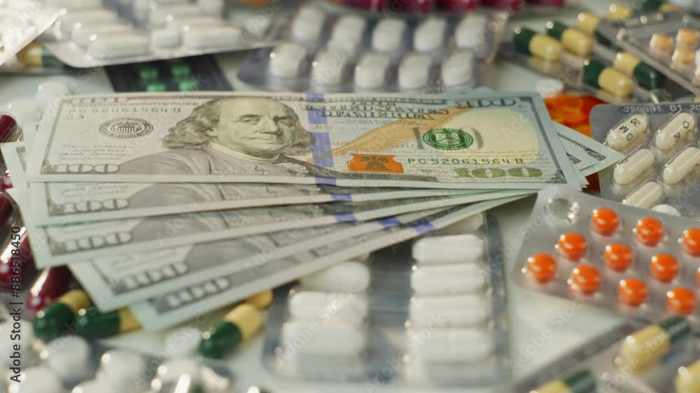 Slow motion video of hundred dollar bills falling on pills. Business and finance in medicine, the high cost of drugs in pharmacies. High quality 4k footage Slow motion video of hundred dollar bills falling on pills. Business and finance in medicine, the high cost of drugs in pharmacies. High quality 4k footage