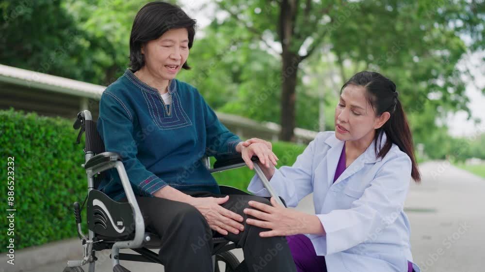 Nurse discussing an elderly lady's knee pain. Happy nurse, wheelchair and elderly care in garden for outdoor walk in retirement.. Caregiver talking to senior person with a disability in healthcare. Nurse discussing an elderly lady's knee pain. Happy nurse, wheelchair and elderly care in garden for outdoor walk in retirement.. Caregiver talking to senior person with a disability in healthcare.