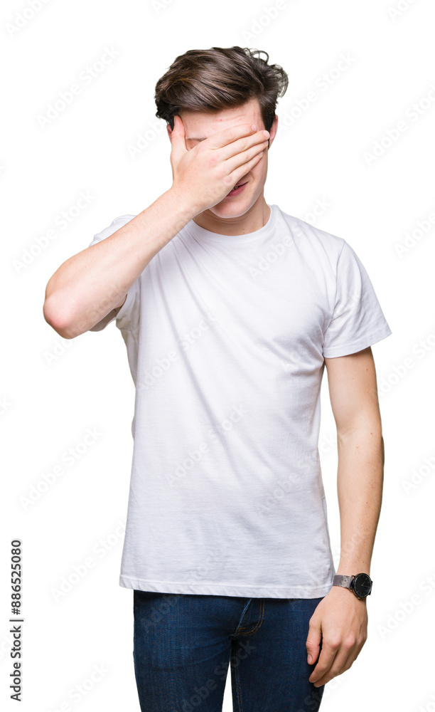 Young handsome man wearing casual white t-shirt over isolated background smiling and laughing with hand on face covering eyes for surprise. Blind concept. Young handsome man wearing casual white t-shirt over isolated background smiling and laughing with hand on face covering eyes for surprise. Blind concept.