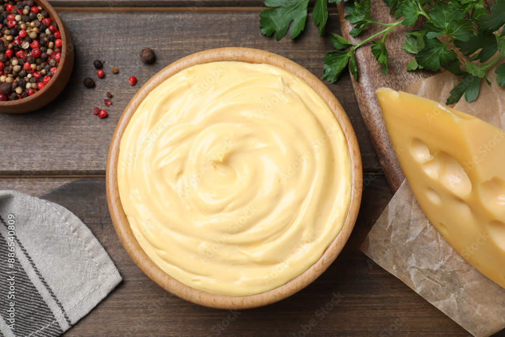 Tasty cheese sauce, pepper and parsley on wooden table, flat lay Tasty cheese sauce, pepper and parsley on wooden table, flat lay