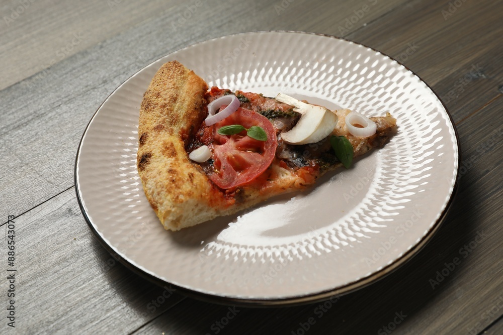 Piece of tasty pizza with mushrooms, basil and tomato on wooden table Piece of tasty pizza with mushrooms, basil and tomato on wooden table