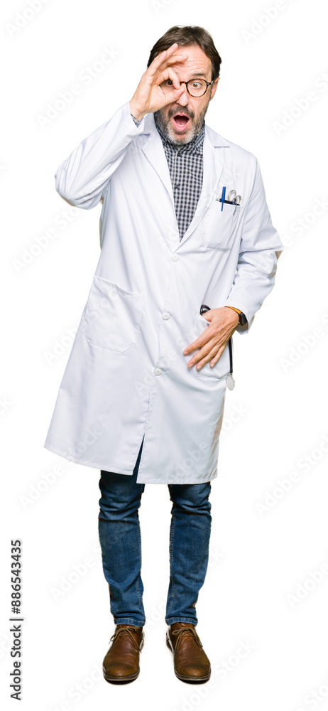 Middle age doctor men wearing medical coat doing ok gesture shocked with surprised face, eye looking through fingers. Unbelieving expression. Middle age doctor men wearing medical coat doing ok gesture shocked with surprised face, eye looking through fingers. Unbelieving expression.