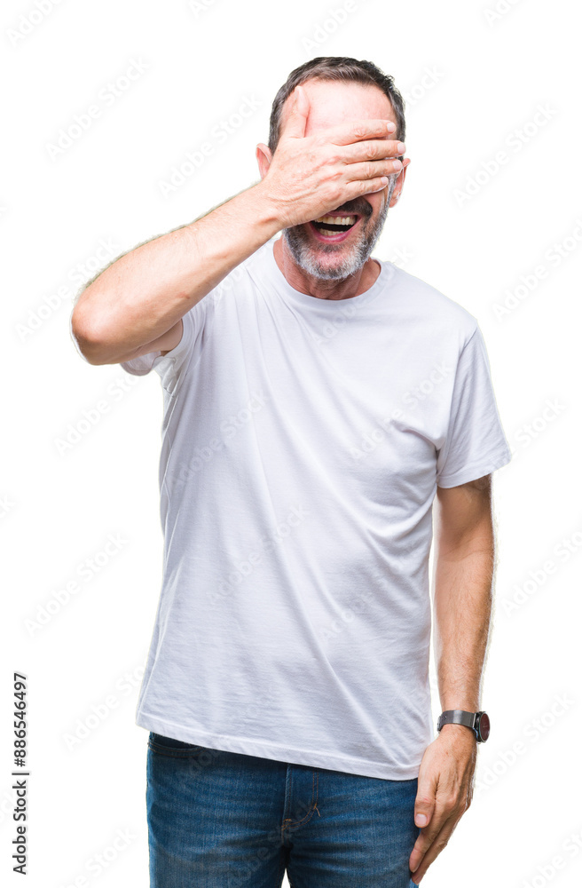 Middle age hoary senior man wearing white t-shirt over isolated background smiling and laughing with hand on face covering eyes for surprise. Blind concept. Middle age hoary senior man wearing white t-shirt over isolated background smiling and laughing with hand on face covering eyes for surprise. Blind concept.