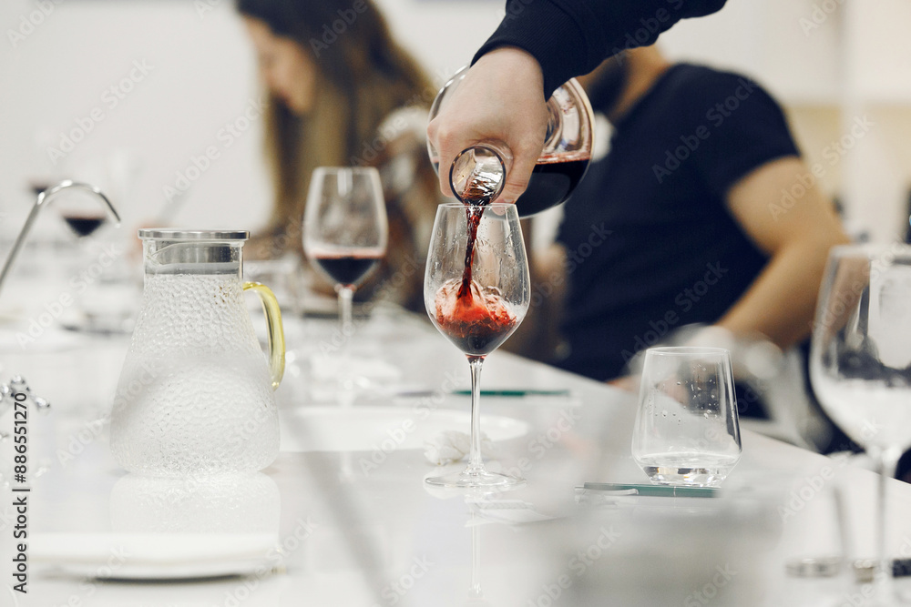 Skilled Person Pouring Decanting Red Wine into Glasses for Course Session of Professional Development Participants Skilled Person Pouring Decanting Red Wine into Glasses for Course Session of Professional Development Participants