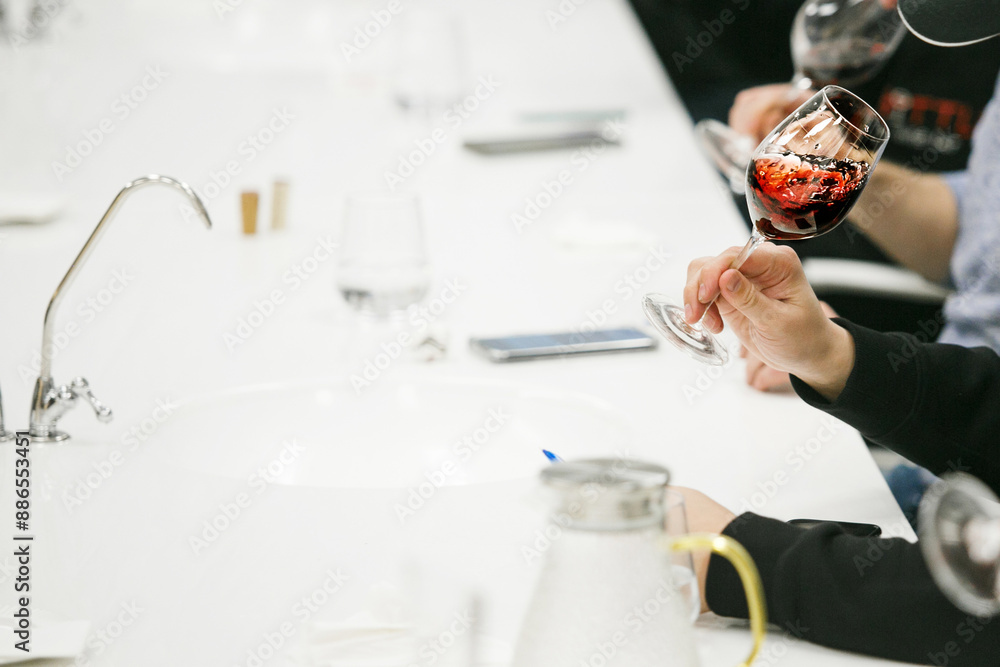 Close-Up Faceless Photo of Swirling Red Wine in Glass at Tasting Event Close-Up Faceless Photo of Swirling Red Wine in Glass at Tasting Event