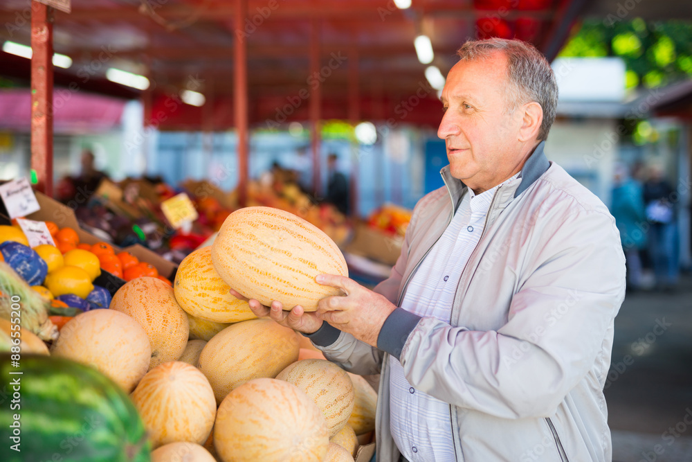 Fototapeta premium Middle aged man buying melon