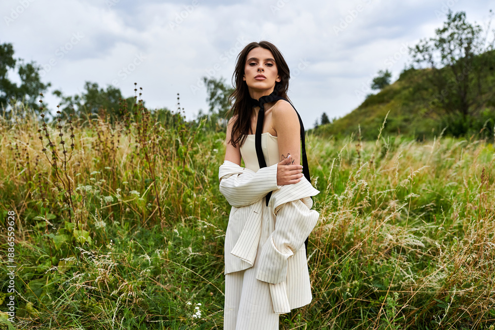 A beautiful young woman in white attire standing gracefully in a field of tall grass, basking in the summer breeze. A beautiful young woman in white attire standing gracefully in a field of tall grass, basking in the summer breeze.