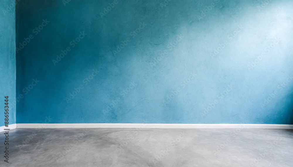 Blue wall in an empty room with concrete floor Blue wall in an empty room with concrete floor