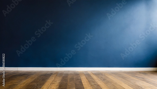 Dark blue wall in an empty room with a wooden floor