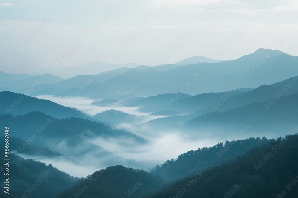 Obraz premium Misty mountain landscape with blue sky.
