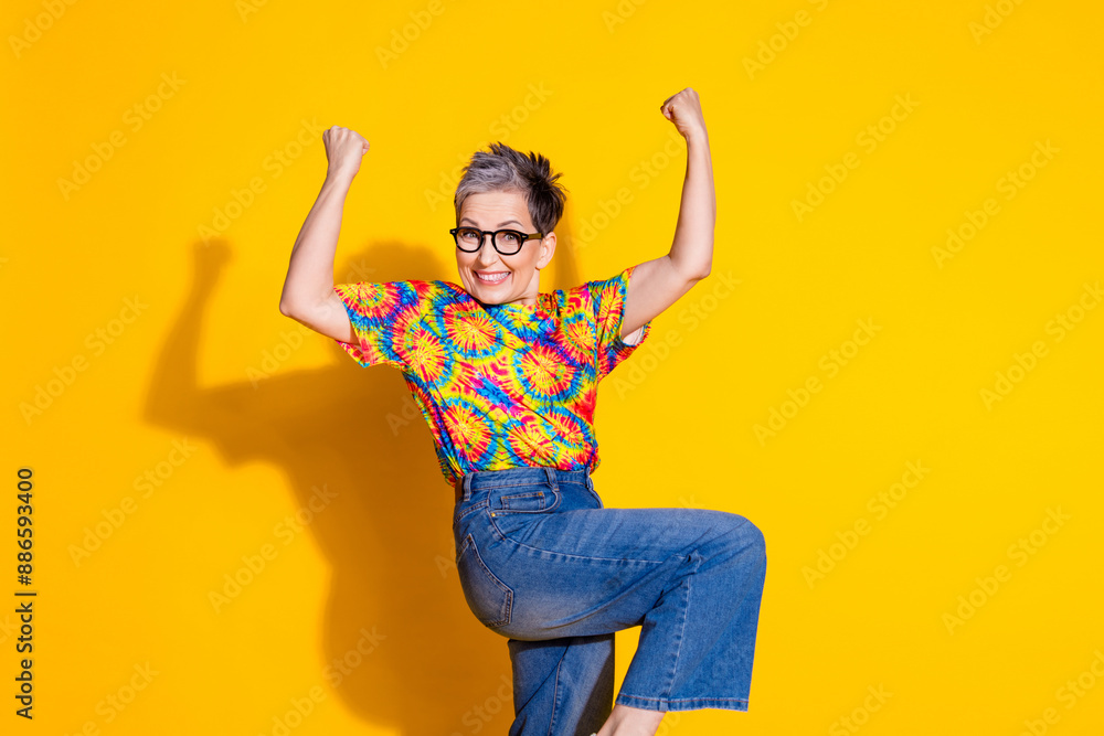 Photo of overjoyed cheerful nice woman wear stylish print clothes isolated on vivid yellow color background Photo of overjoyed cheerful nice woman wear stylish print clothes isolated on vivid yellow color background
