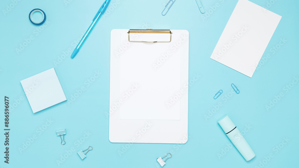 Creative flat lay mockup design of workspace. Top view composition with white notebook, to do list and stationery on blue background Creative flat lay mockup design of workspace. Top view composition with white notebook, to do list and stationery on blue background
