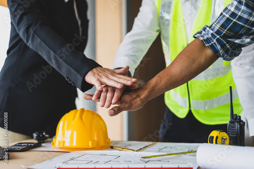 Businessman, contractors and engineers working at construction sites are construction inspector and supervise the work according to plans. Coworker cooperation and teamwork to ensure workplace safety. © Wasan