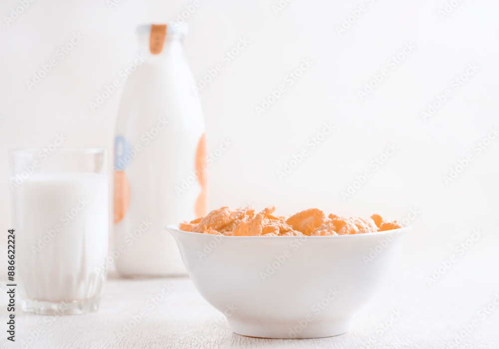 bowl of corn granola with milk, fresh raspberries, blueberries . milk in a jug and a glass on white wooden board for healthy breakfast bowl of corn granola with milk, fresh raspberries, blueberries . milk in a jug and a glass on white wooden board for healthy breakfast