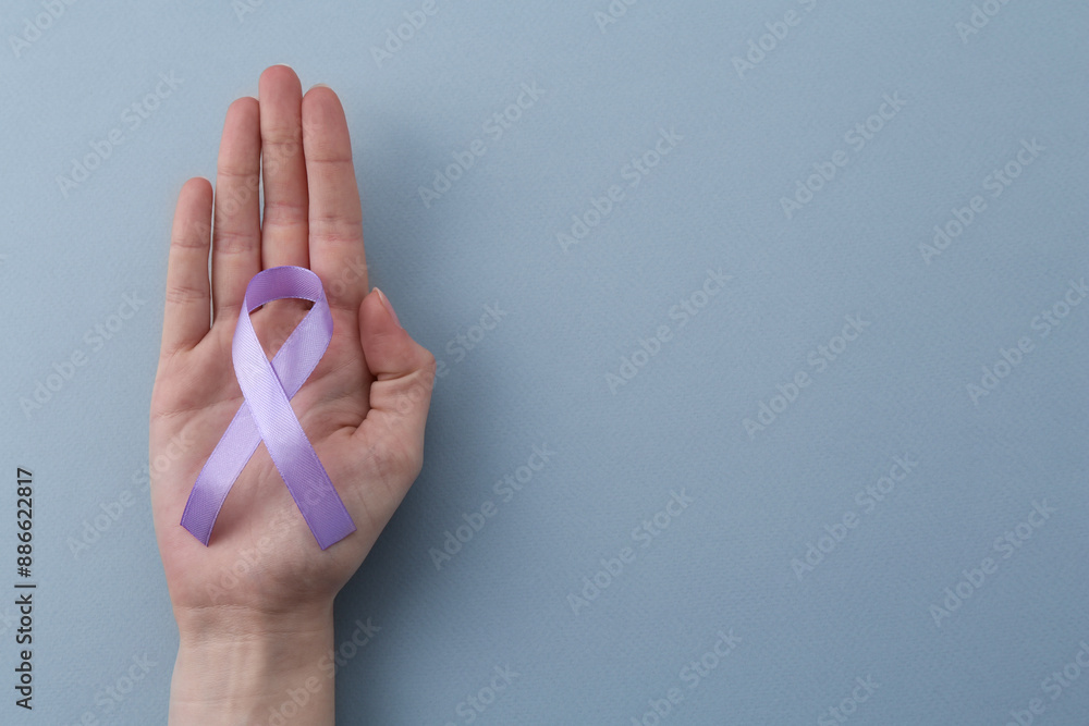 Naklejka premium Woman with violet awareness ribbon on light blue background, top view. Space for text