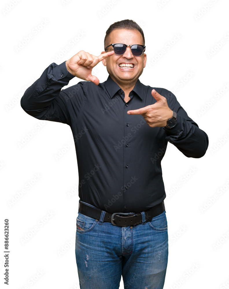 Fototapeta premium Middle age arab man wearing sunglasses over isolated background smiling making frame with hands and fingers with happy face. Creativity and photography concept.