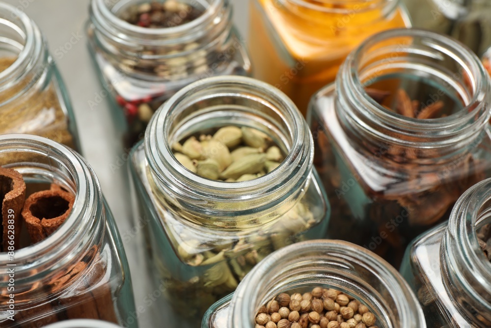 Different spices in glass jars on table, closeup Different spices in glass jars on table, closeup