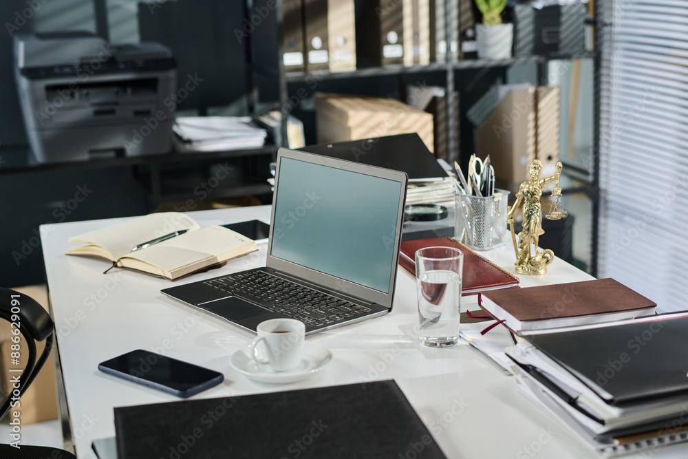 Desk with laptop of lawyer, open notepad with working notes, glass of water, cup of coffee or tea, mobile phone and other supplies Desk with laptop of lawyer, open notepad with working notes, glass of water, cup of coffee or tea, mobile phone and other supplies