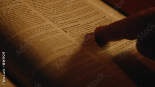 A believer is reading the Bible book on a desk in soft candle light, spiritual practice, Close up, High quality 4k footage