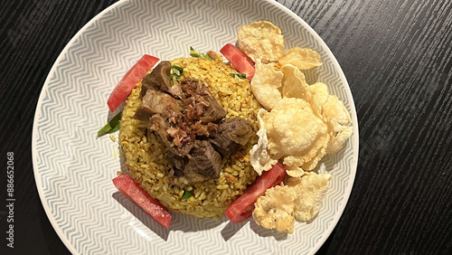 Arabian fried rice cooked with fried lamb, rice, garlic, tomatoes, and emping melinjo crackers photo