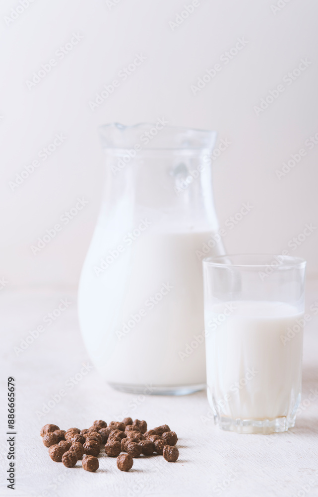 Milk in a glass and chocolate balls on a light background. Milk in a glass and chocolate balls on a light background.