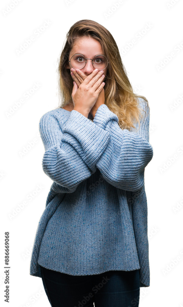 Young beautiful blonde woman wearing sweater and glasses over isolated background shocked covering mouth with hands for mistake. Secret concept. Young beautiful blonde woman wearing sweater and glasses over isolated background shocked covering mouth with hands for mistake. Secret concept.