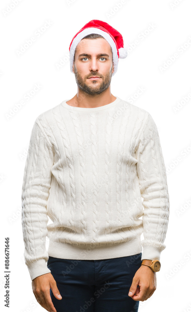 Young handsome man wearing santa claus hat over isolated background with serious expression on face. Simple and natural looking at the camera. Young handsome man wearing santa claus hat over isolated background with serious expression on face. Simple and natural looking at the camera.