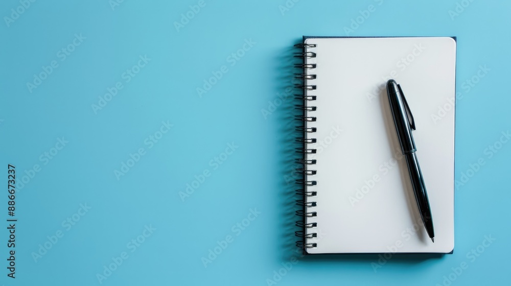 Blank notebook and pen from above on light blue background with space for text idea for notes and organization Blank notebook and pen from above on light blue background with space for text idea for notes and organization