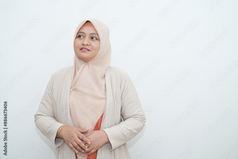 Fototapeta premium Portrait of a beautiful young Asian Muslim woman wearing a hijab being photographed in a studio