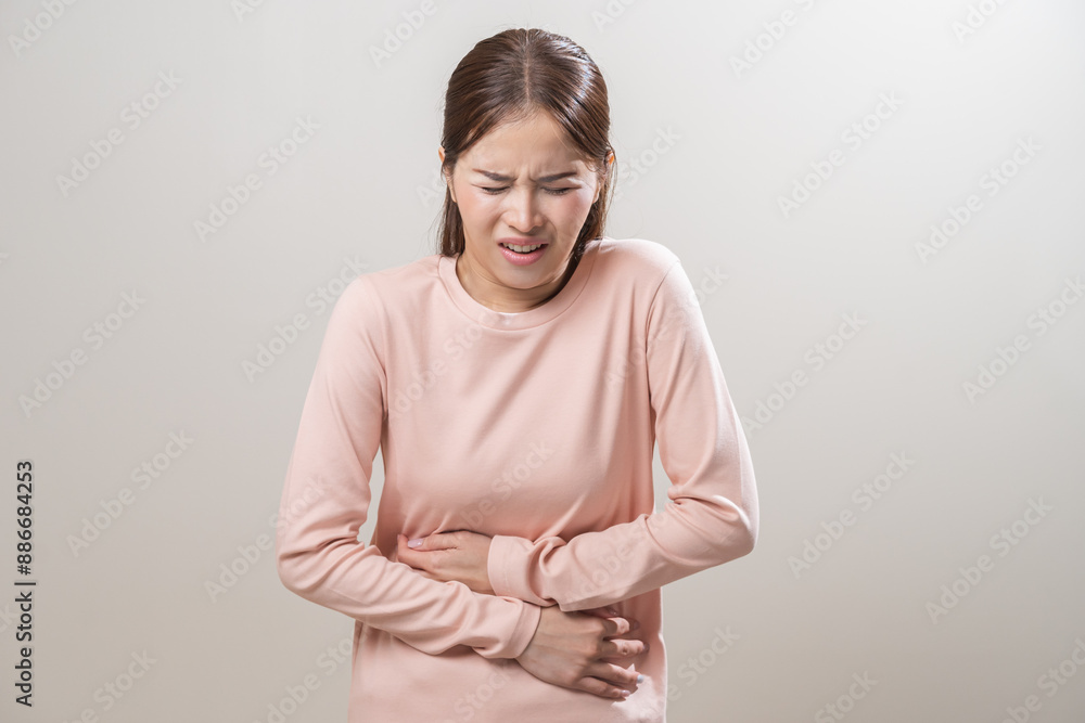 Flatulence asian young woman intolerance hand in stomach ache, suffer from food poisoning, abdominal pain and colon problem, gastritis or diarrhoea when at home. Patient belly, abdomen or inflammation